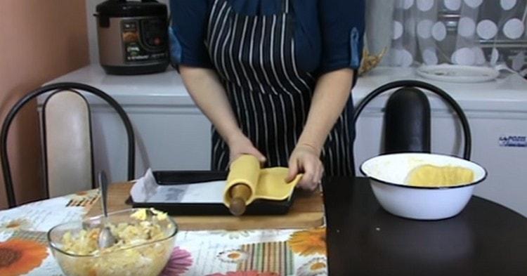 С помощта на точилка прехвърлете слой тесто върху лист за печене, покрит с пергамент.