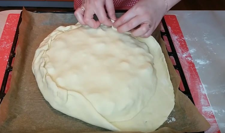 Разточете второто парче тесто, покрийте го с пай и прищипете краищата.
