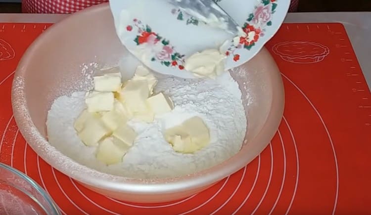 Fügen Sie Scheiben Butter Mehl hinzu und zerdrücken Sie in eine Krume mit einer Gabel.