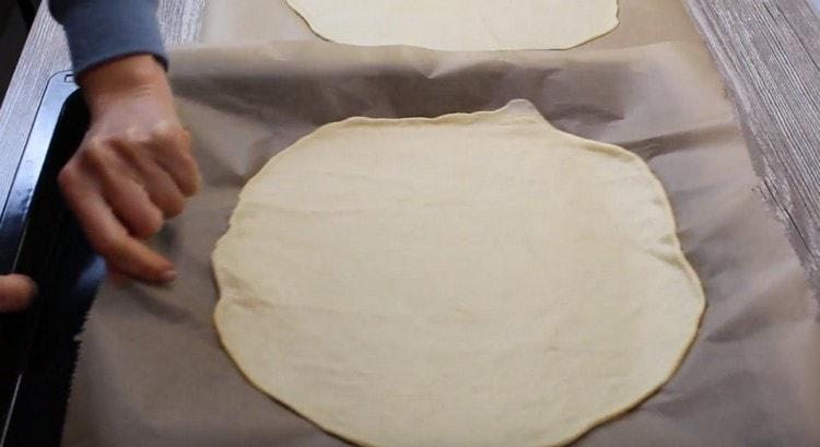 Kasama ang parchment, ilipat ang kuwarta sa isang baking sheet.
