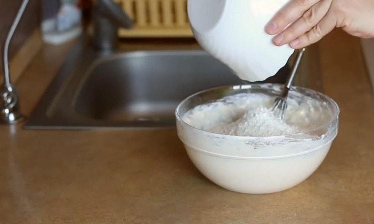 Postupně přidávejte mouku do tekutých složek a hnětete těsto.