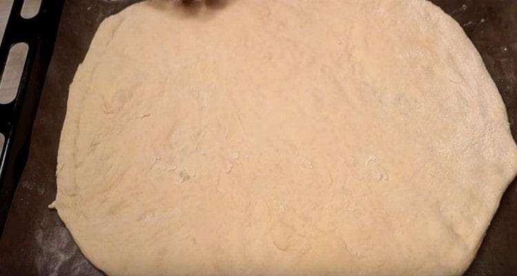 Прехвърляме кръга тесто върху лист за печене, покрит с пергамент.