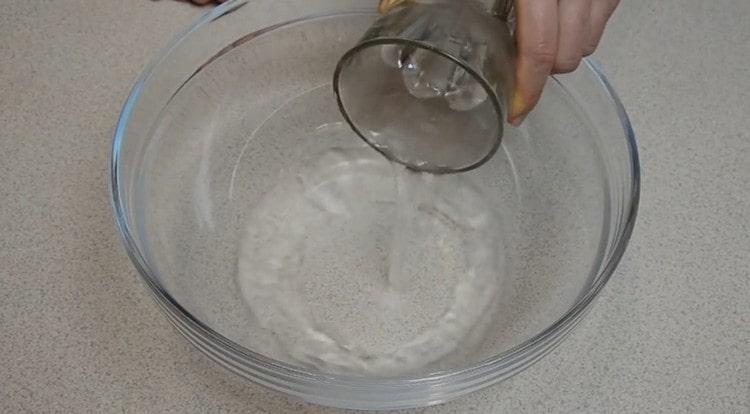 Gießen Sie warmes Wasser in eine Schüssel, um den Teig zu kneten.