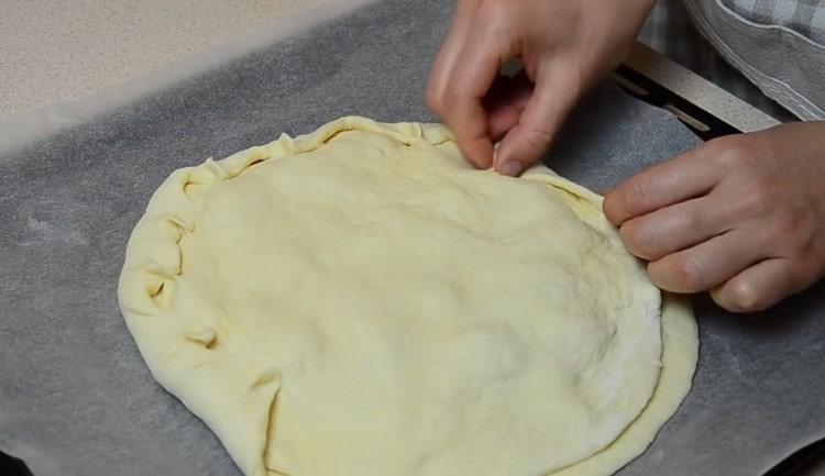 Покрийте пълнежа с друго парче тесто и внимателно притиснете краищата.