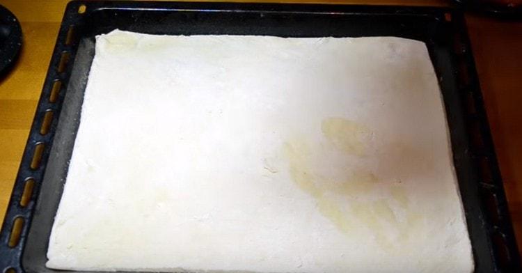 Разточете тестото на тънко и прехвърлете върху лист за печене.
