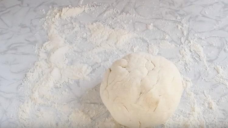 Rotoliamo l'impasto nella farina, formando una palla.