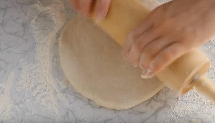 Stendere la pasta in un cerchio con un mattarello.