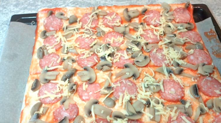 Pizzu posypte strouhaným sýrem.