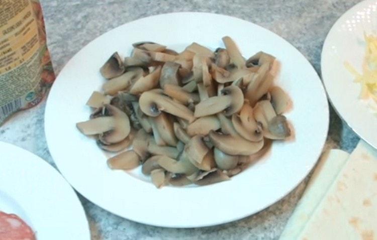 Lessare i funghi prataioli in acqua salata e tagliarli a fettine sottili.