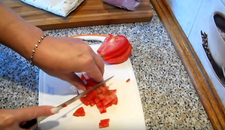 Schinken und Tomate in Würfel schneiden.