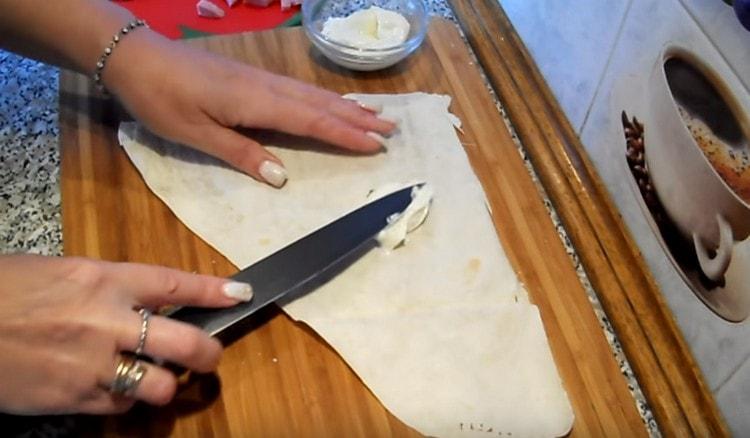Namažte jednu část chleba pita smetanovým sýrem.