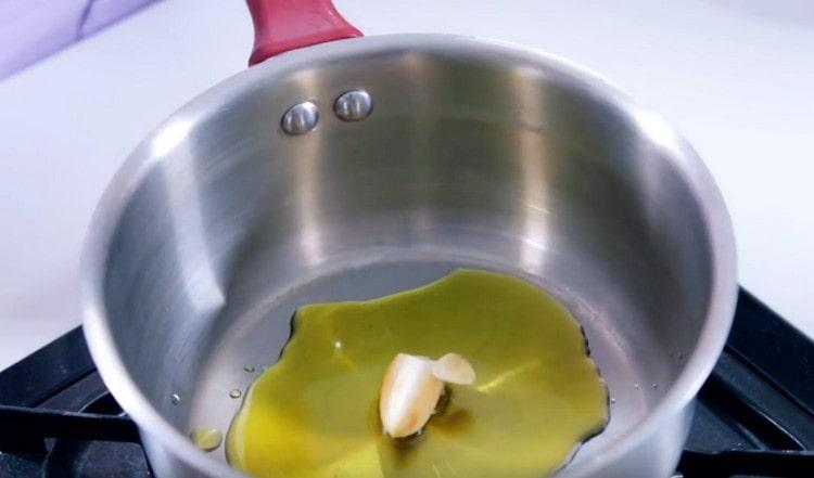Gießen Sie Olivenöl in die Pfanne und geben Sie den Knoblauch hinein.