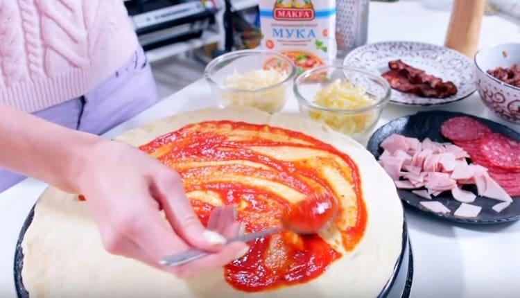 Намажете тестото с доматен сос.