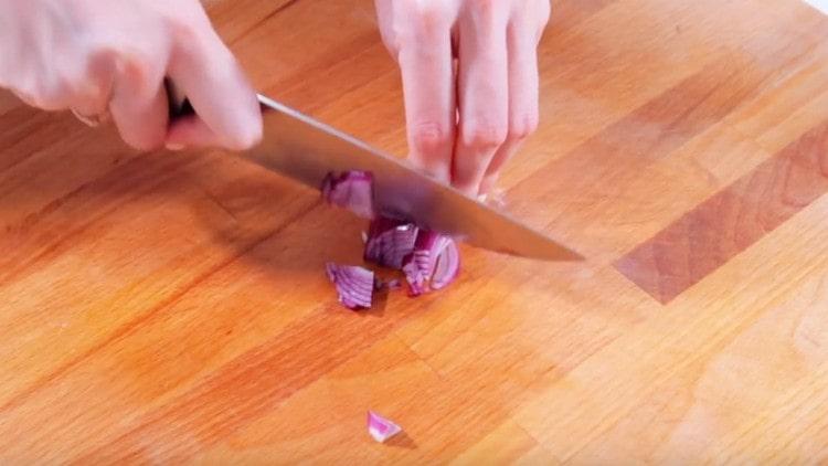 Taglia un pezzetto di cipolla viola in un cubetto.