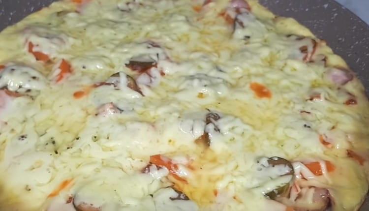 Οι άκρες της πίτσας θα πρέπει να ροδίσουν και το τυρί να λιώσει.