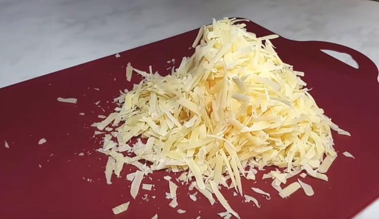Grattugiare il formaggio su una grattugia.