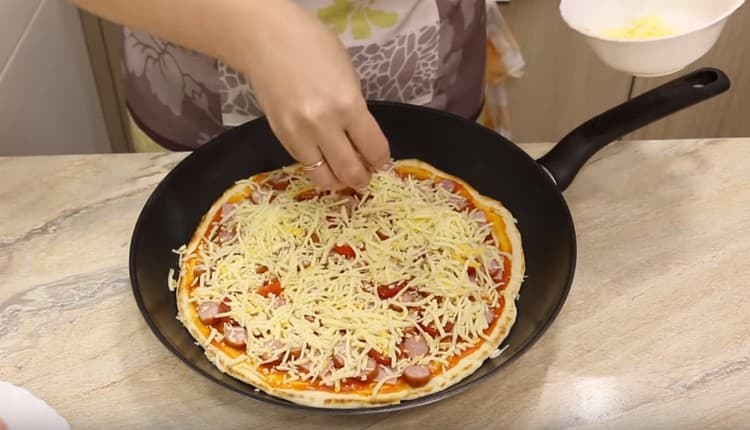 يرش البيتزا مع الجبن.