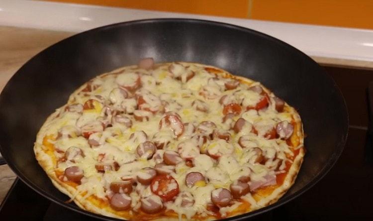 Kun pizzan reunat ovat kypsyneet ja juusto sulaa, se on valmis.