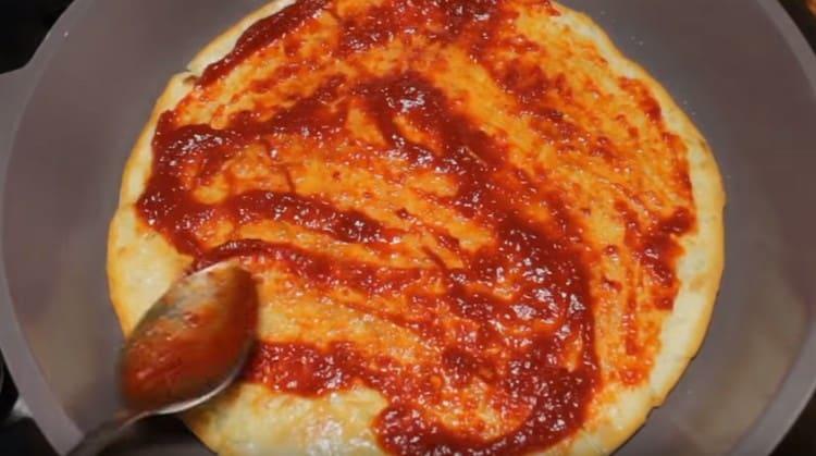 Fetten Sie unsere Pizzabasis sofort mit Tomatensauce ein.