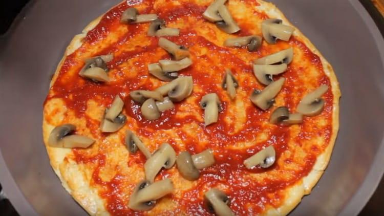 Distribuiamo funghi sulla pizza.