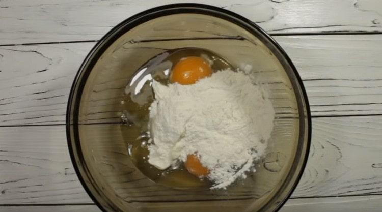 Добавете сол, заквасена сметана и брашно към яйцата.