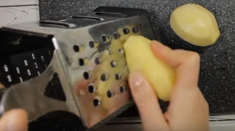 Reiben Sie die Kartoffeln auf einer Reibe.
