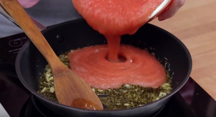 Į keptuvę supilkite pjaustytus pomidorus.