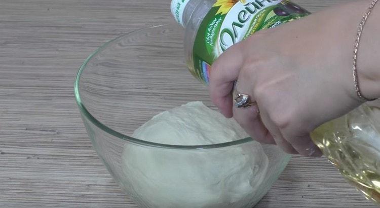 Разпределяме тестото в купа, намазана с растително масло, също е намазана с олио.
