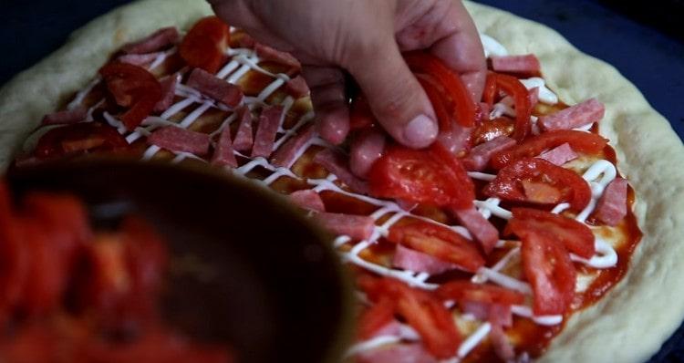 Levitämme tomaattiviipaleita makkaran päälle.
