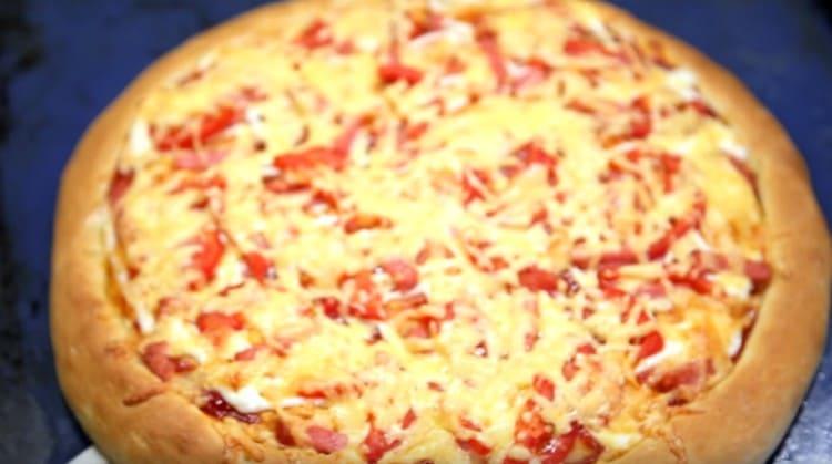 Pizza s klobásou a sýrem a rajčaty je připravena!
