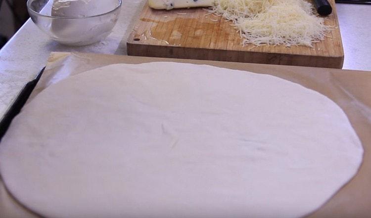 Szétterítjük a tésztát egy pergamentel borított sütőlapra.