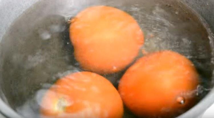 Nachdem wir die Tomaten kreuzförmig eingeschnitten haben, verteilen wir sie in kochendem Wasser.