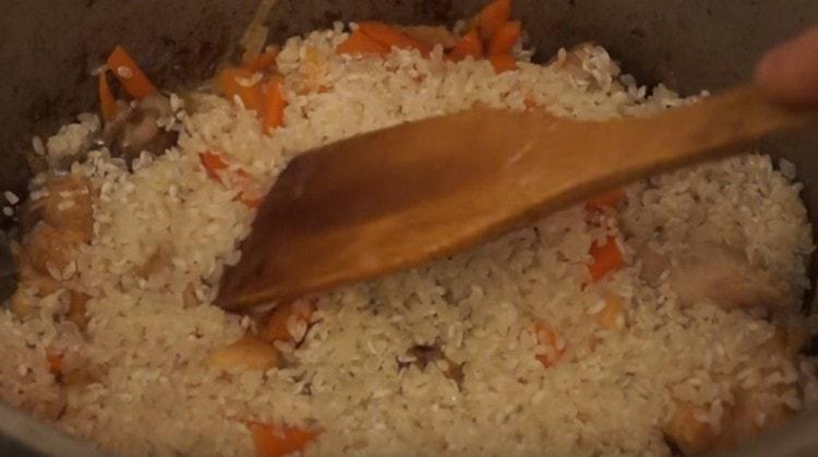 A zöldségek tetejére fektessen egy réteg mosott rizst.
