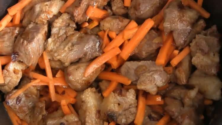 Braten Sie die Karotten gemäß dem Rezept, um Pilaw in einem langsamen Kocher zu kochen