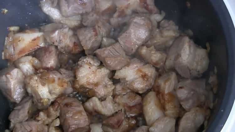 Braten Sie das Fleisch gemäß dem Rezept, um Pilaw in einem langsamen Kocher zu kochen
