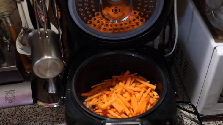 Leikkaa porkkanat ohuiksi suikaleiksi ja laita ne monitoimikoneen kulhoon.