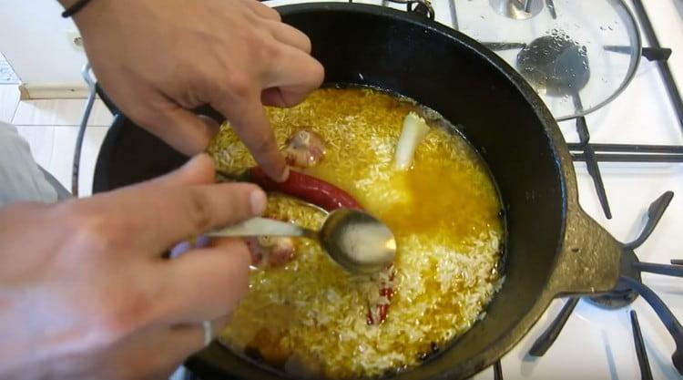 Προσθέστε το σκόρδο στο ρύζι, καθώς και ζεστό πιπέρι.