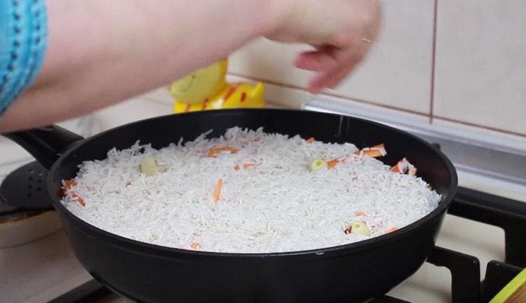 Legen Sie die Knoblauchzehen in den Reis, Salz.