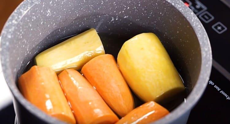 ρίχνετε το φυτικό έλαιο στα καρότα και βάζετε μια κατσαρόλλα στη σόμπα.