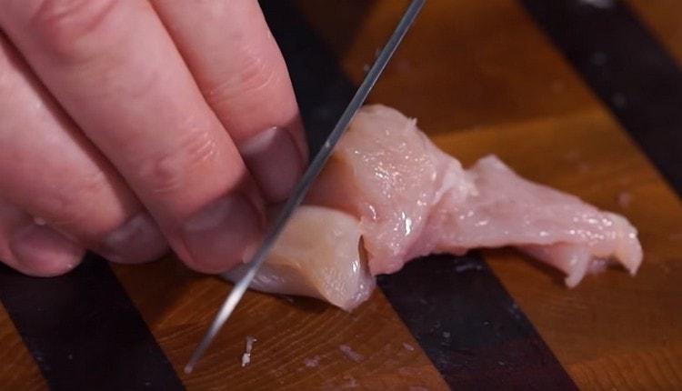 Tagliamo separatamente la carne dal petto di pollo e la carne rossa dalle cosce.