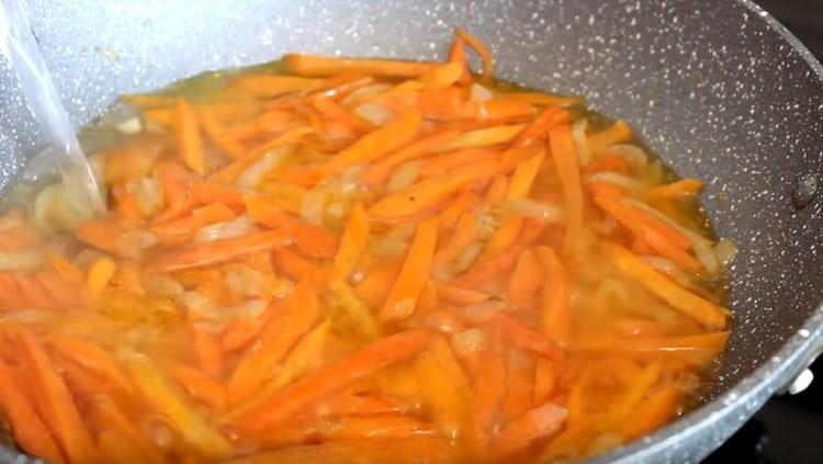 Wenn die Karotten weich werden, geben Sie Wasser in die Pfanne.