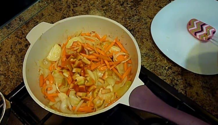 Wir hacken die Paprika und geben die Karotten und Zwiebeln in die Pfanne.