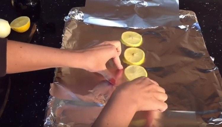 Покрийте листа за печене с фолио и върху него сложете лимонови кръгчета.