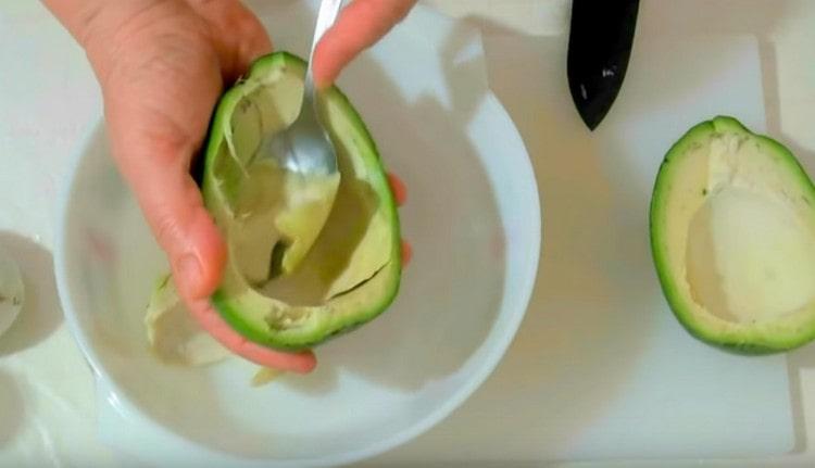 Внимателно лъжица пулпа от авокадо и прехвърлете в купа.