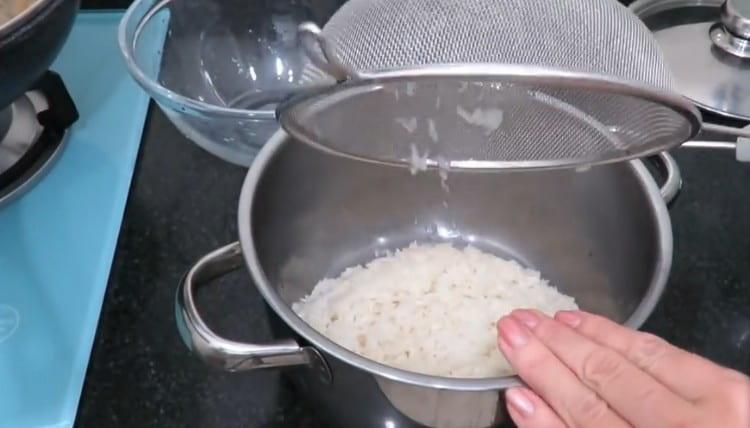 نغسل الأرز جيدًا ونسكبه في المقلاة.