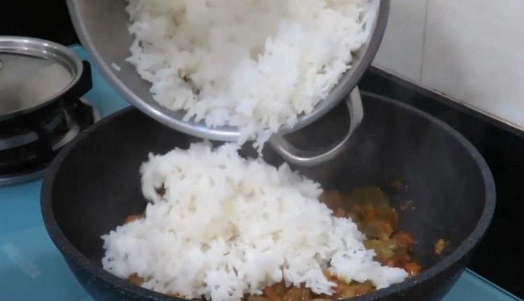 Когато влагата се изпари от месото, добавете към него ориз и разбъркайте.
