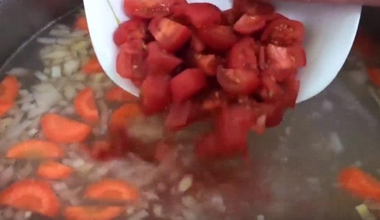 Aggiungi i pomodori e la semola alla zuppa per addensarli leggermente.