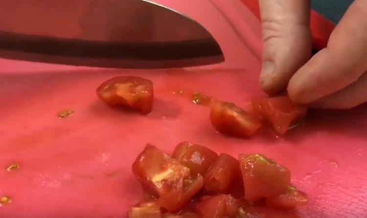 Нарежете обелените домати на парчета.