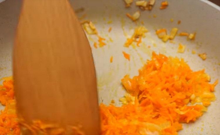 Fügen Sie der Zwiebel Karotten hinzu und braten Sie sie noch einige Minuten.