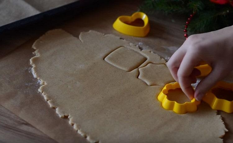 Naudodami sausainių pjaustytuvus, išspauskite sausainių tešlą.